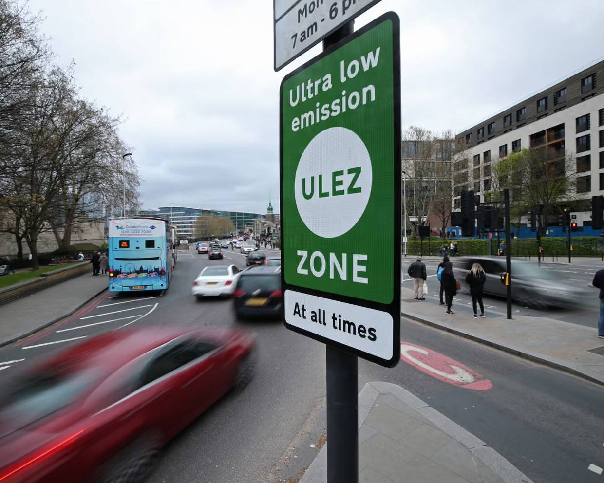 Green "ULEZ" signs with cars driving on the road