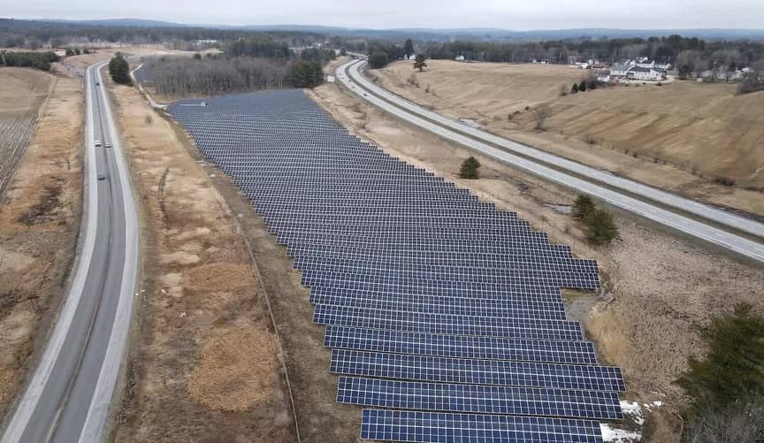 A field of solar panels between two highways