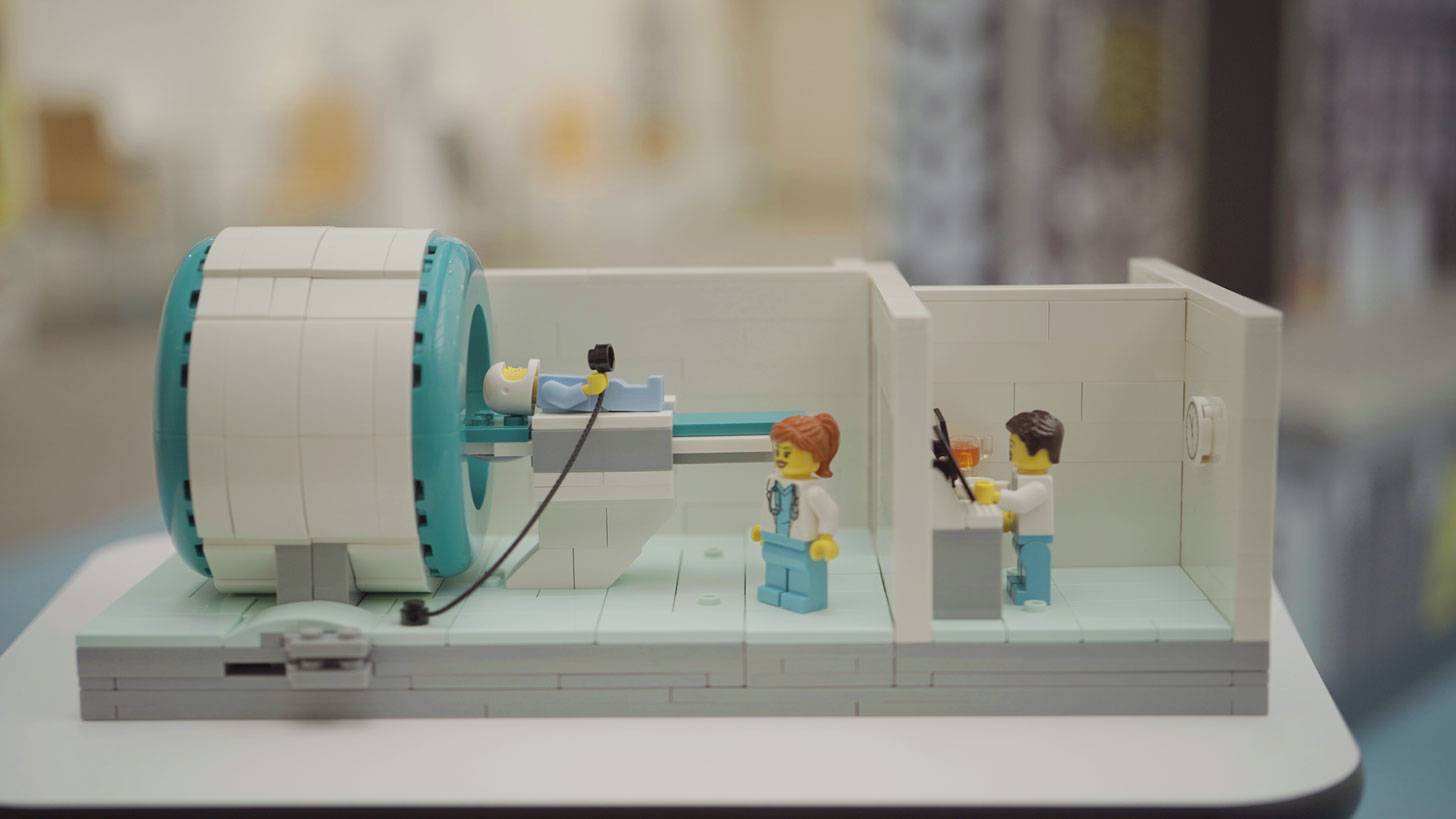 A lego MRI scanner with doctors and a patient
