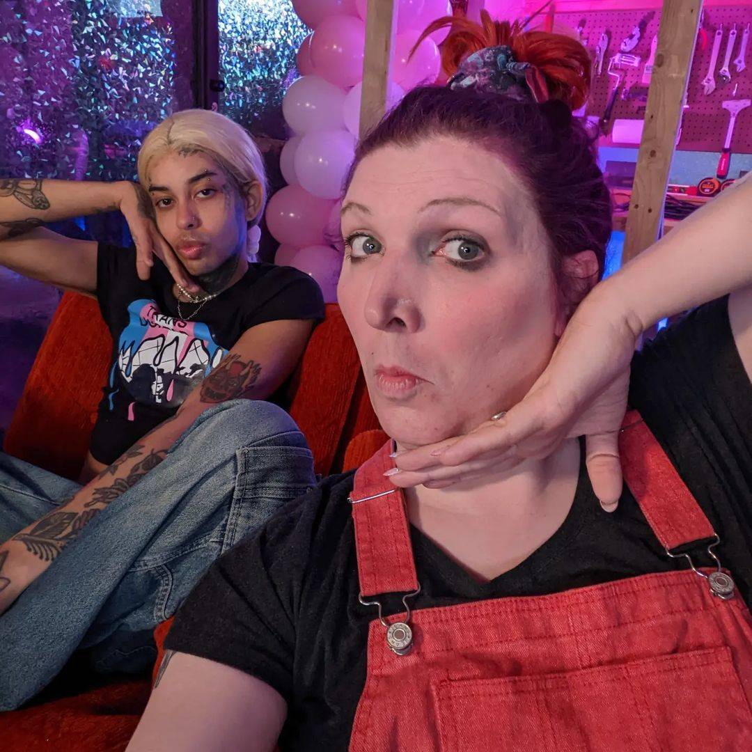 A selfie of Mercury Stardust with Jory on a chair in the background