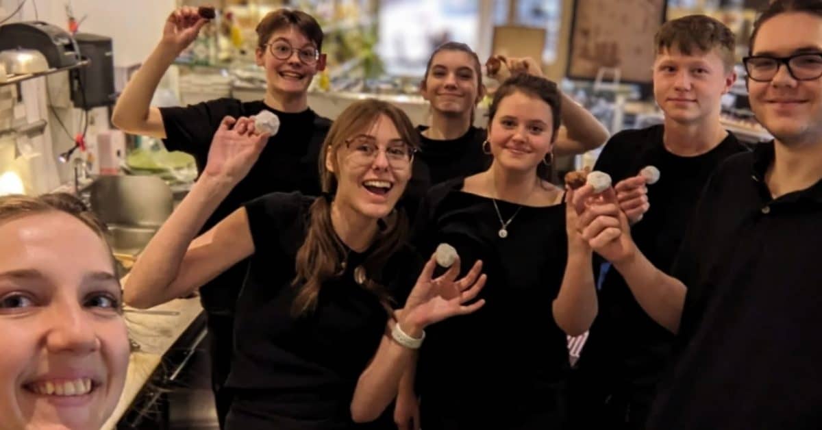 Selfie of a group of seven teens wearing all-black in a restaurant