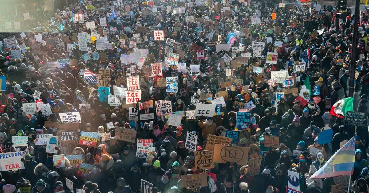A massive crowd holding protest signs