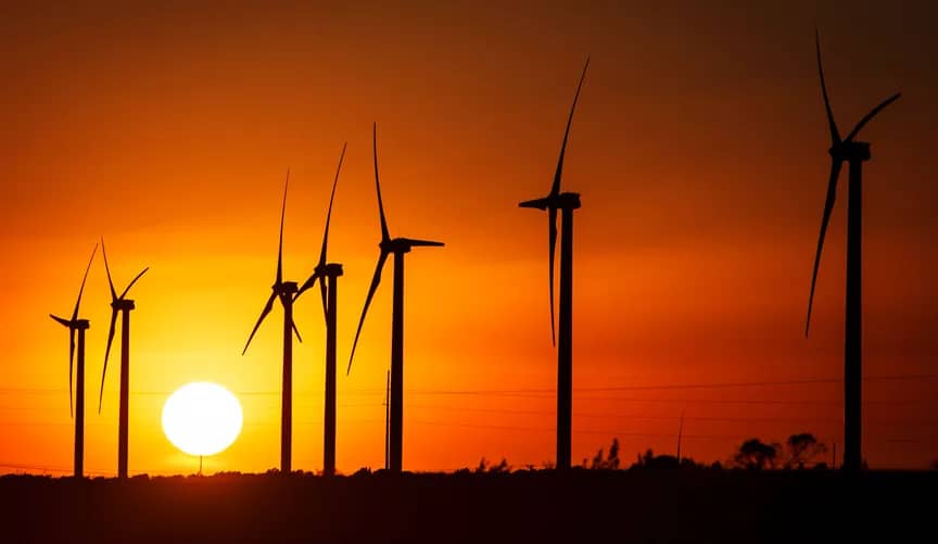 Wind turbines against a sunset