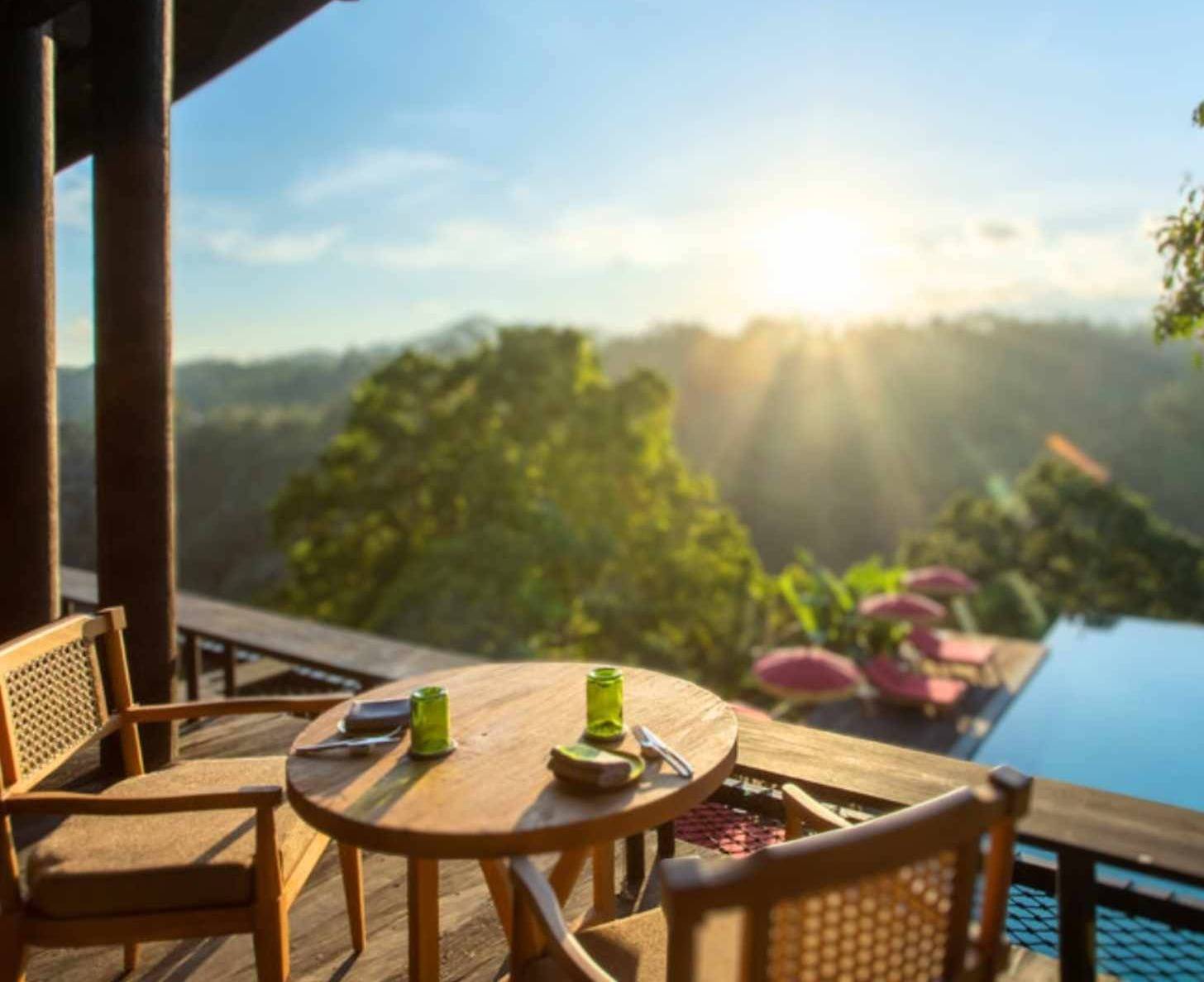 A table set for two overlooking a tree canopy