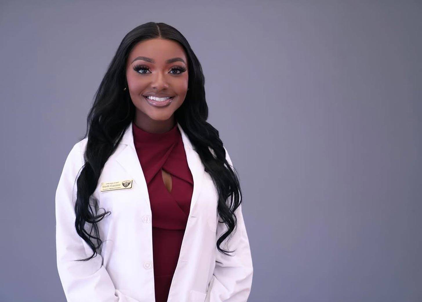 Steffi Casimir in a white lab coat on a grey background