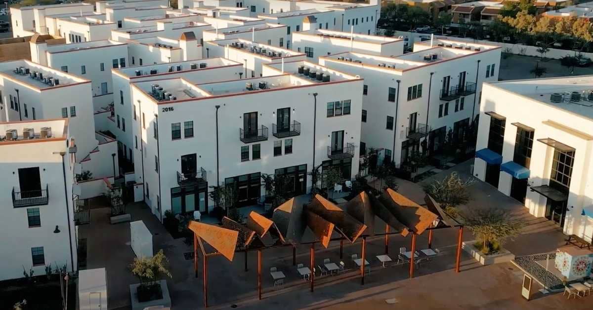 Birds-eye view of a housing development, the exteriors are white with black railings