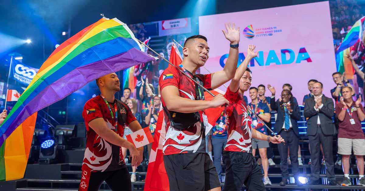 A group of Canadian athletes carrying a pride flag