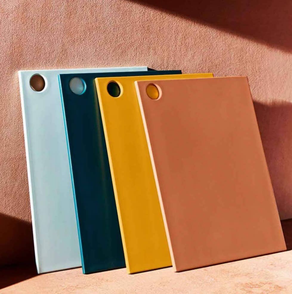 Four colored cutting boards leaning against a wall