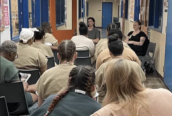 People sitting in chairs facing two other people sitting in chairs