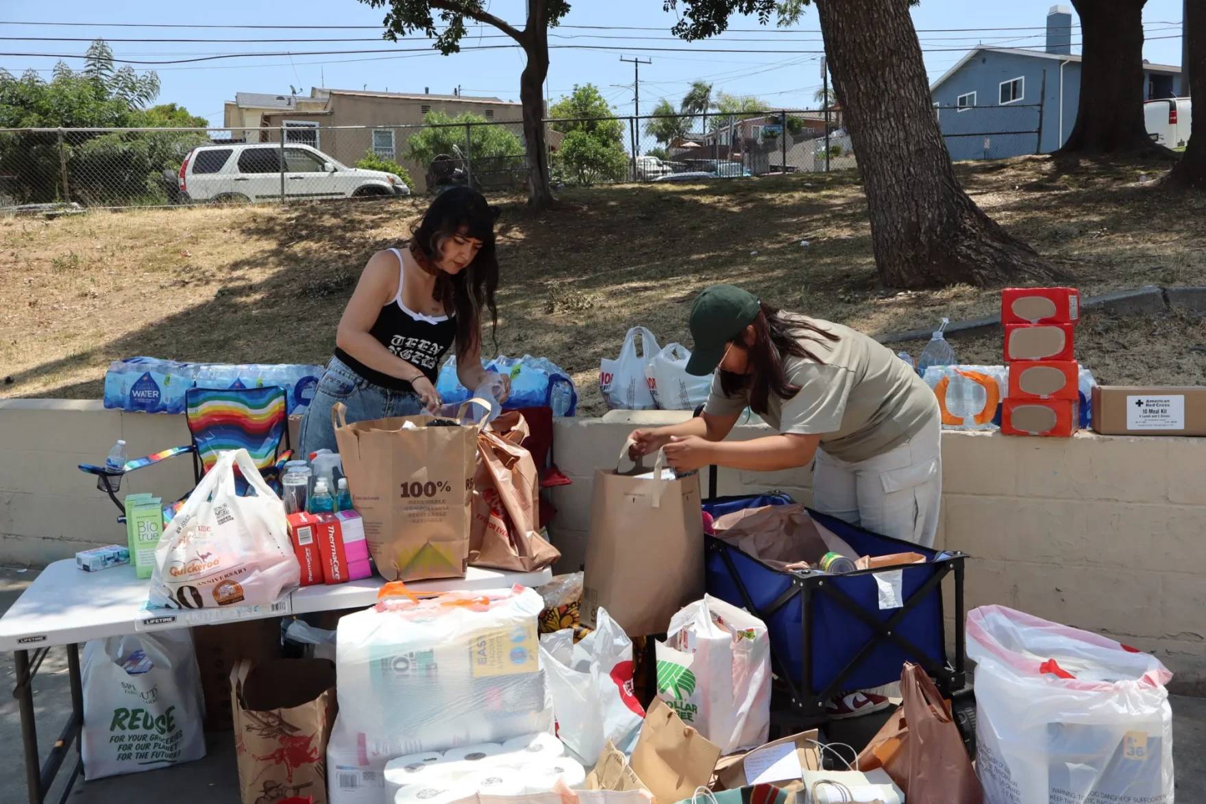 Two people sorting bags of supplies