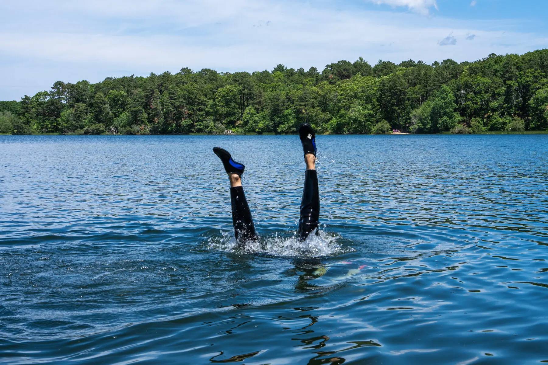 Legs above the surface of the water after someone dove in