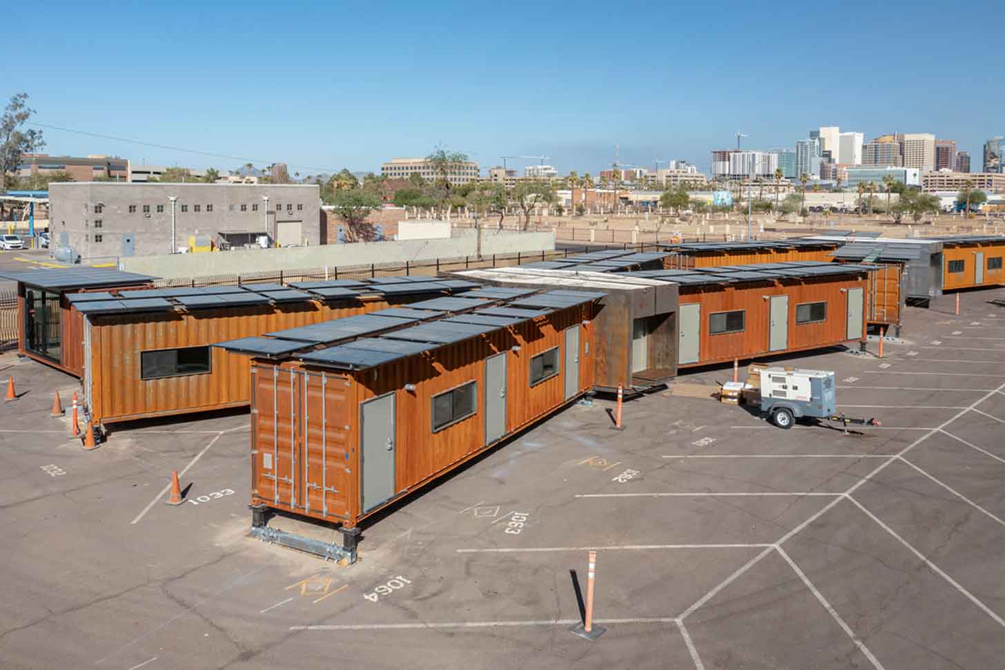 Birds-eye view of an x-shaped housing structure with solar panels on top
