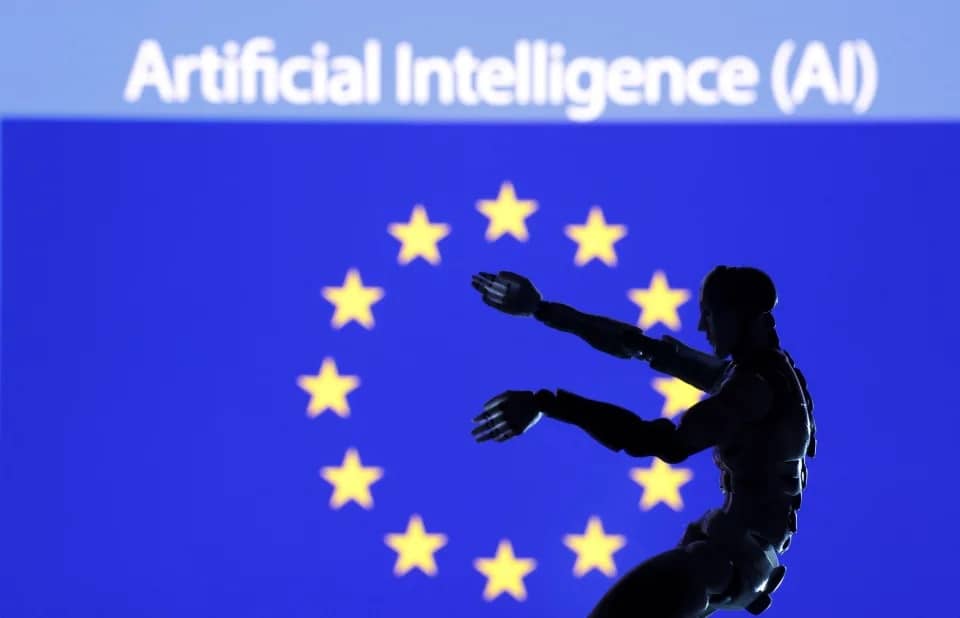 A robotic looking mannequin in front of a screen showing the EU flag with "Artificial Intelligence (AI)" text above it