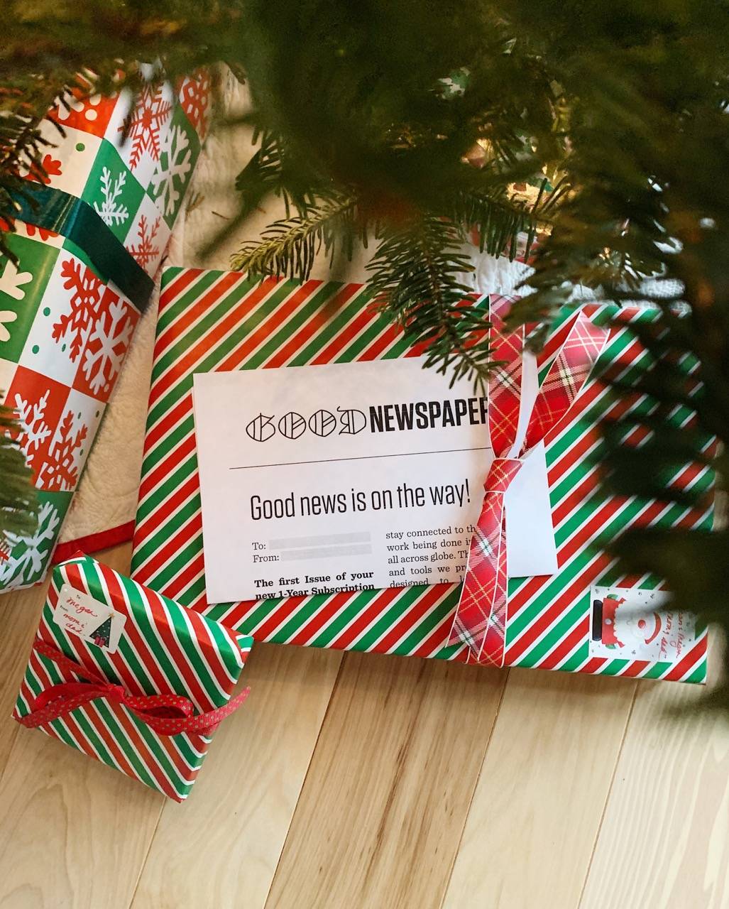 A Goodnewspaper gift certificate wrapped under a tree