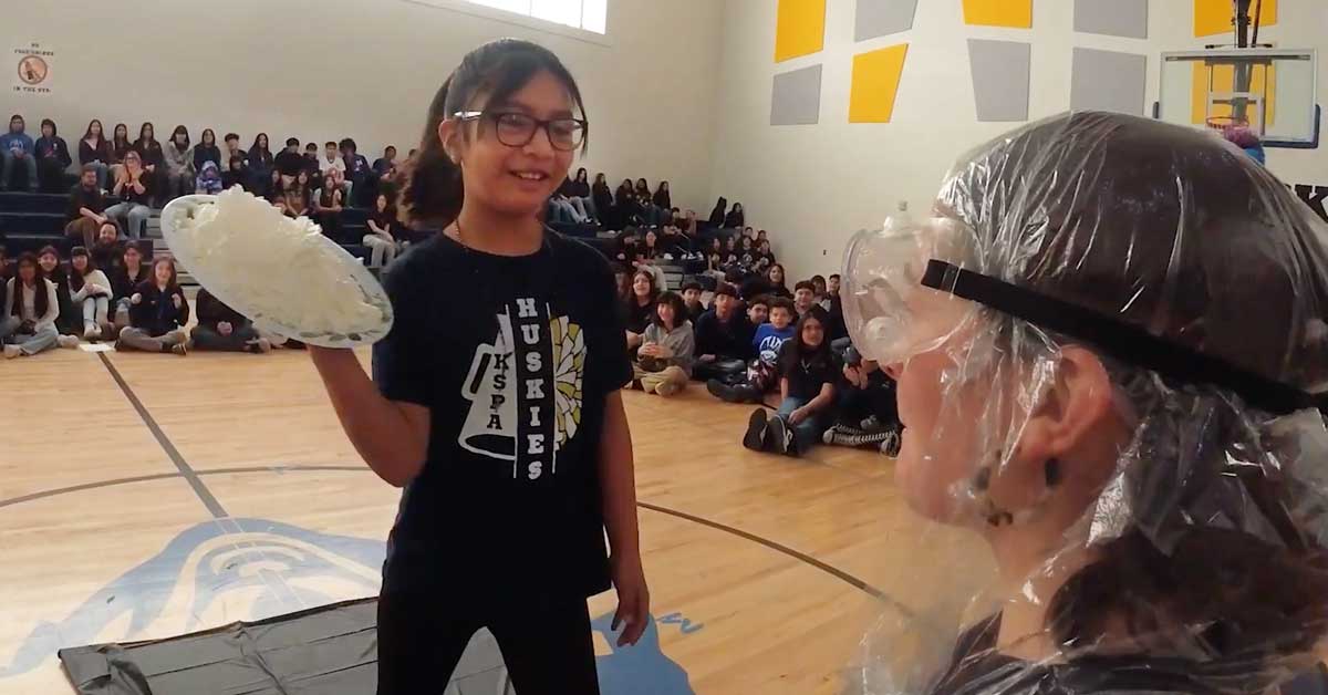 A student putting a "pie" in a teacher's face