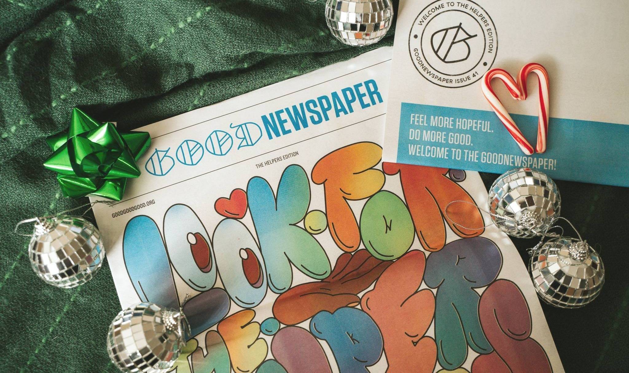 A print newspaper with mirror ball ornaments, a green bow, and candy canes around it