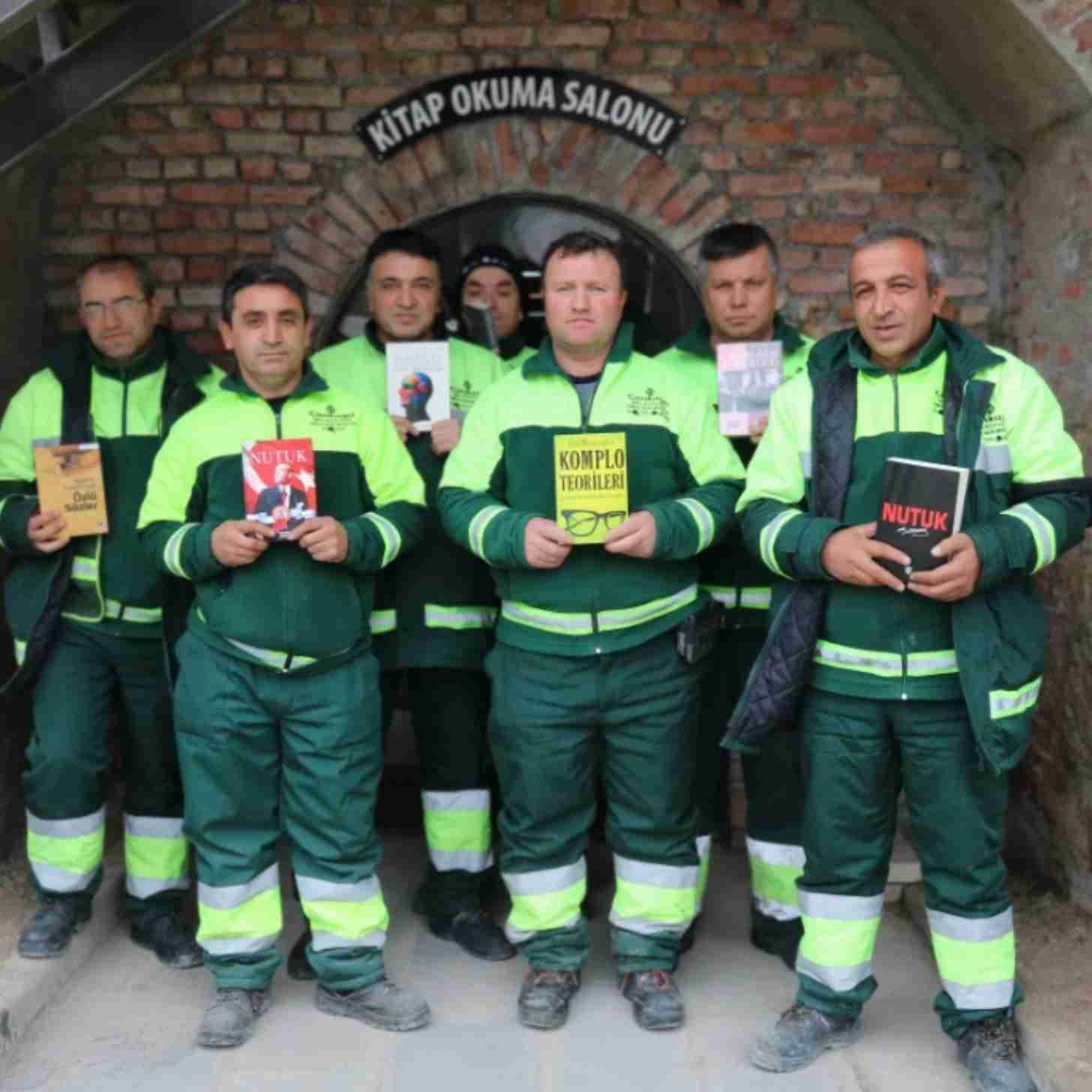 Seven sanitation workers holding books