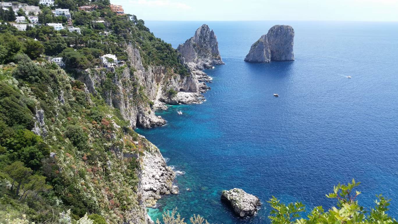 Birds-eye view of the Gulf of Naples, cliff on the left and blue water to the right