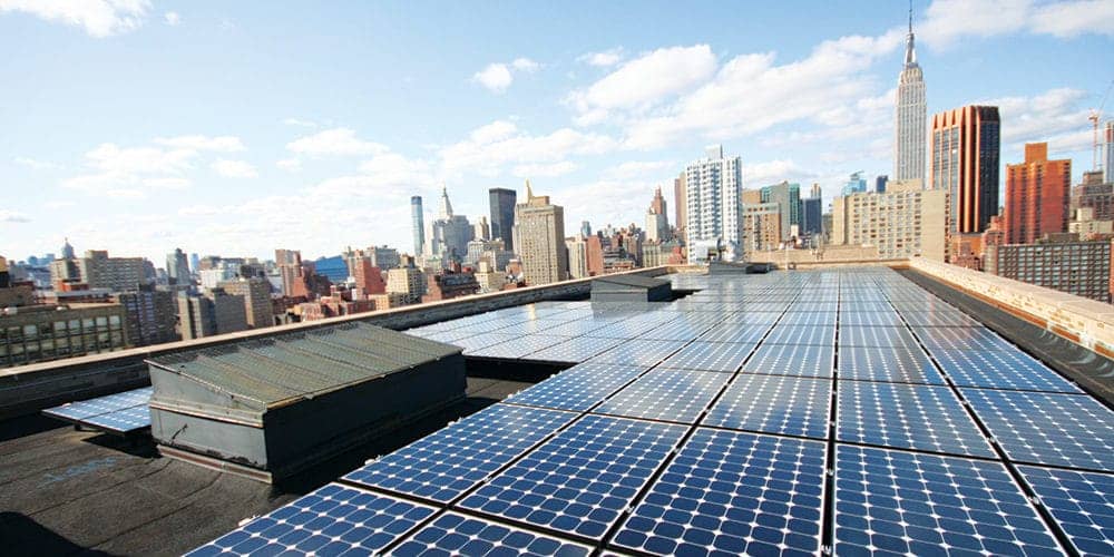 Solar panels on top of a building with NYC skyline in the background