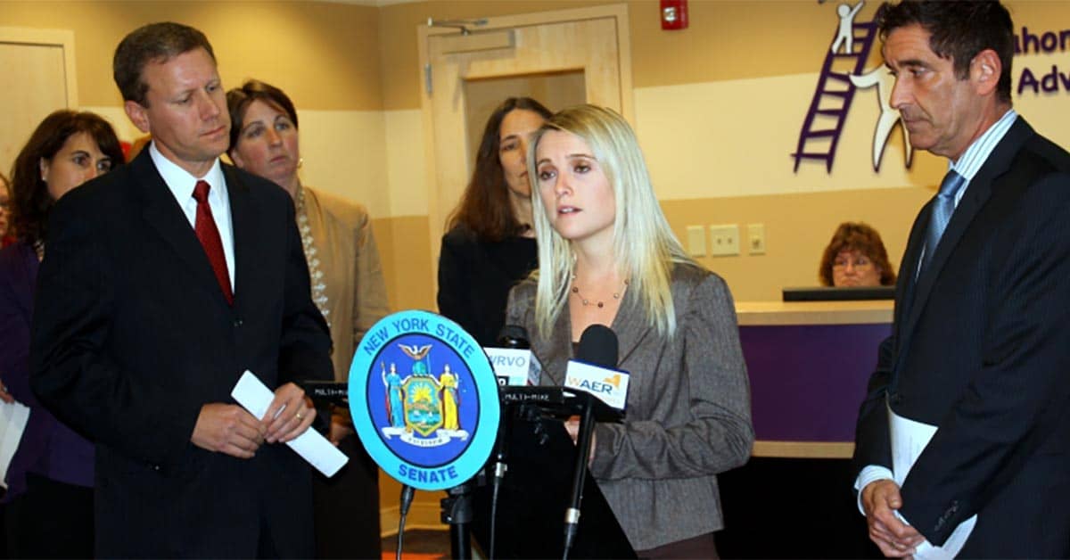 Erin Merryn talking into microphones standing at a podium