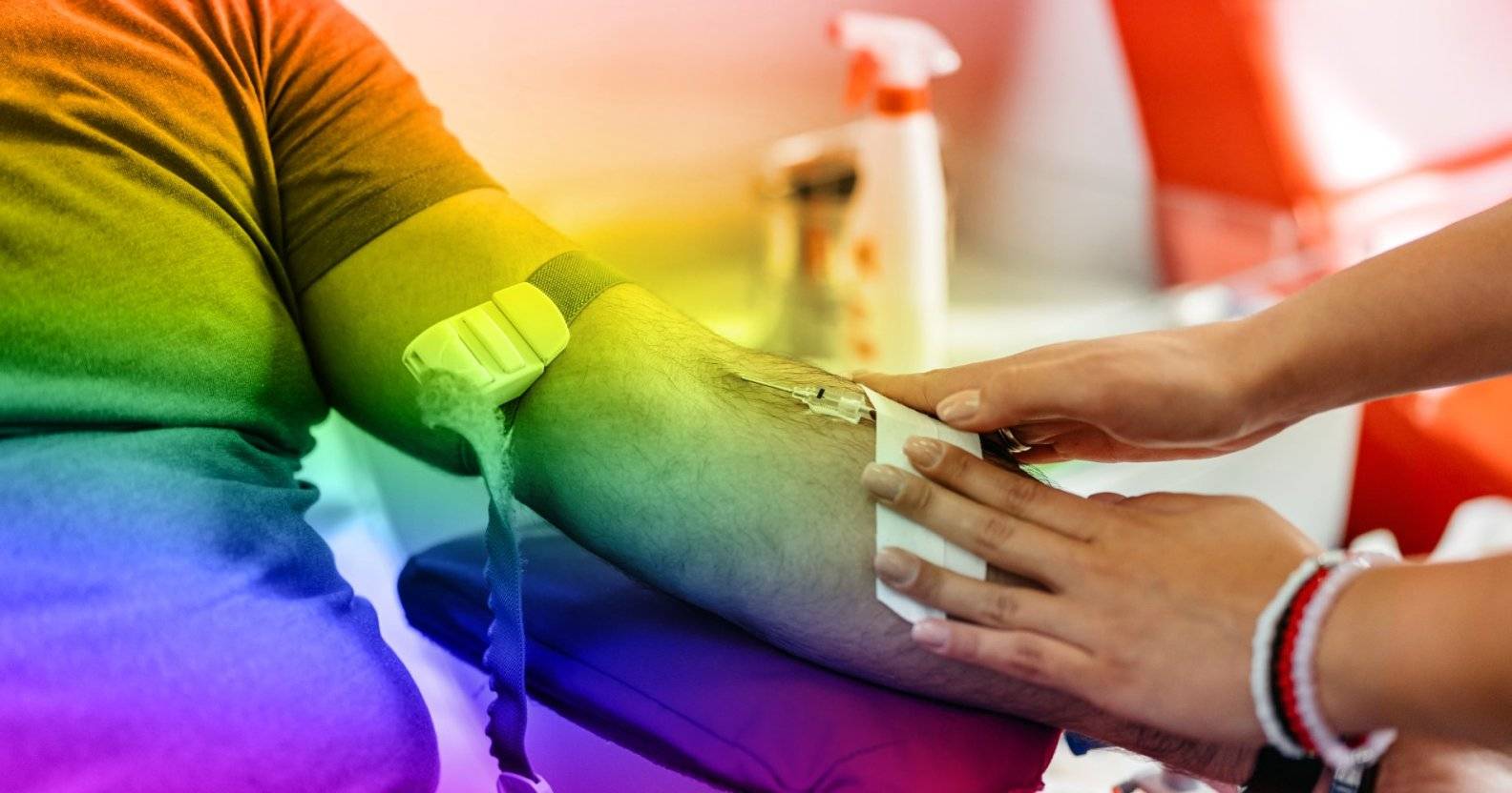 Person giving blood, there's a rainbow filter over the photo