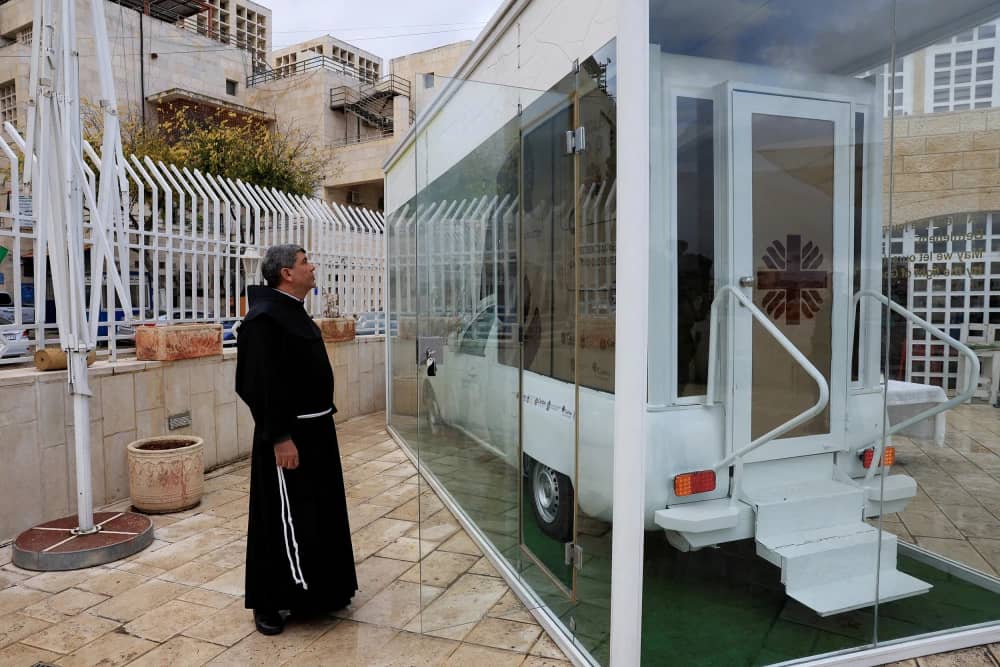 A clergy member looking at the renovated popemobile