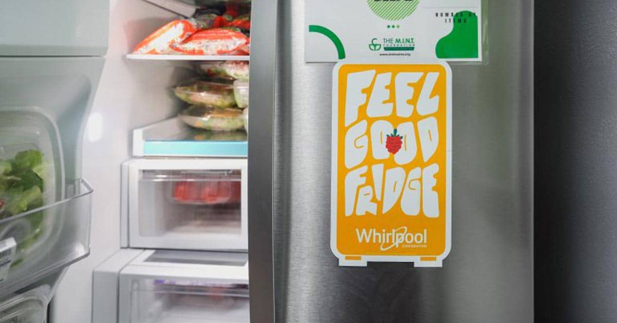 A silver refrigerator with the left door open and a "Feel Good Fridge" magnet on the right door