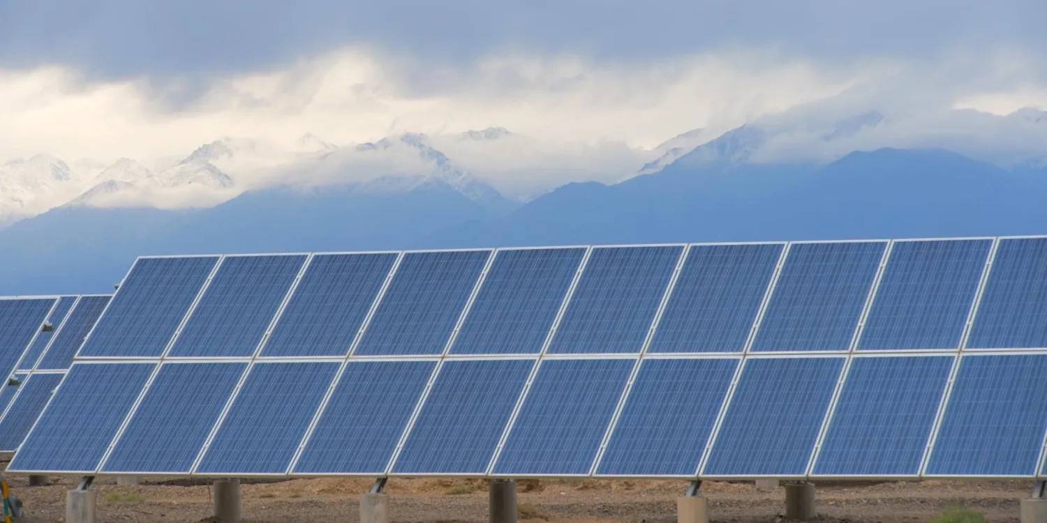 Rows of solar panels with mountains in the background