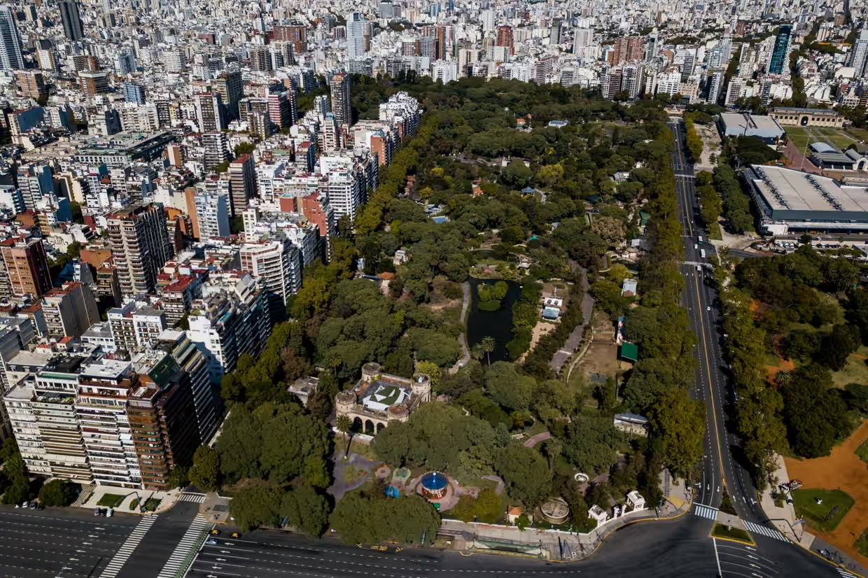 Aerial photo of a tree-covered area surrounded by high rise buildings