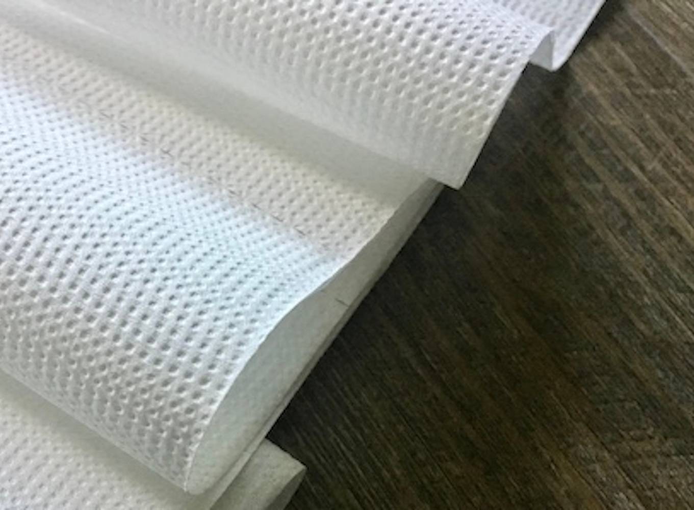 Close-up photo of the texture on a roll of toilet paper