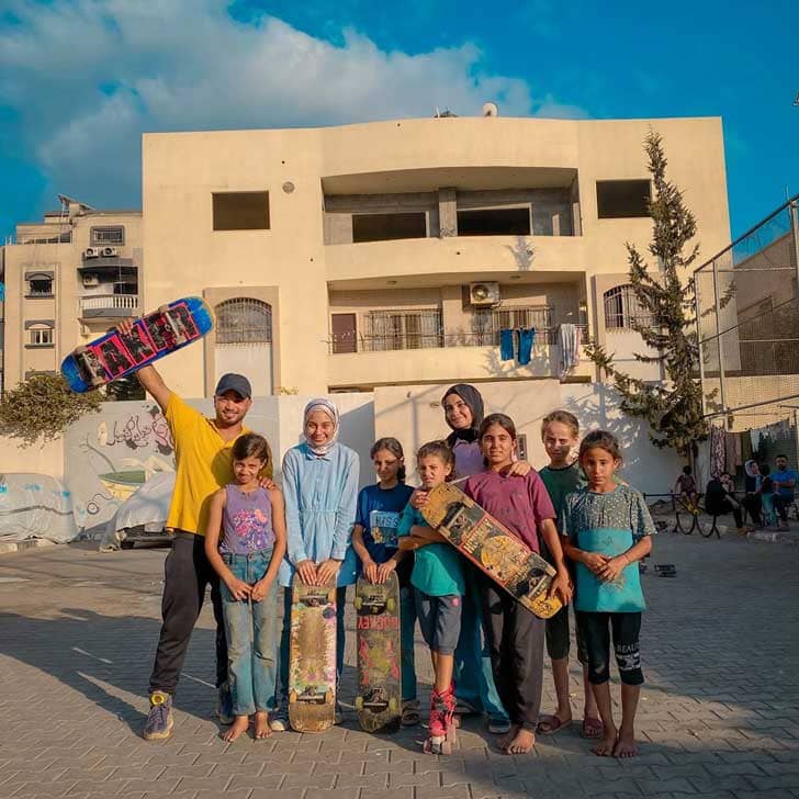 A group of nine people holding skateboards