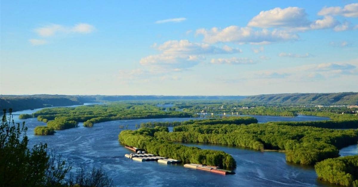 An aerial photo of a waterway with lush green land throughout