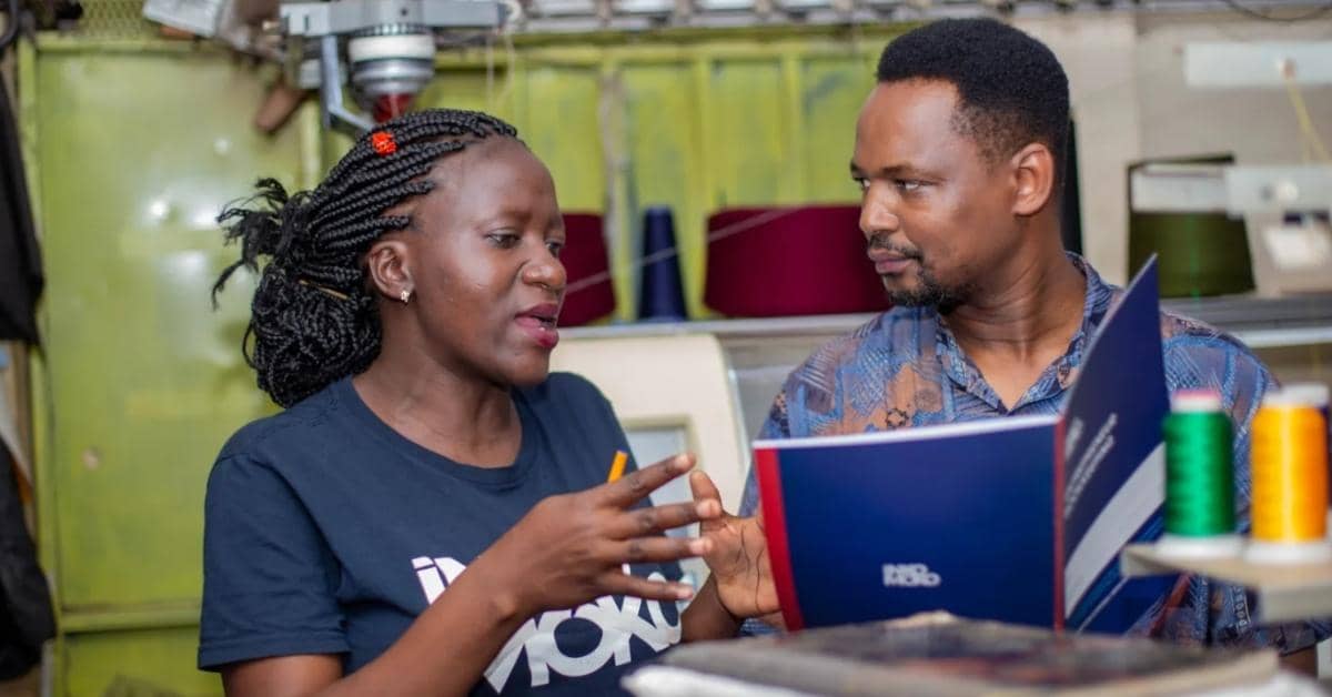 Two people talking and looking at a folder