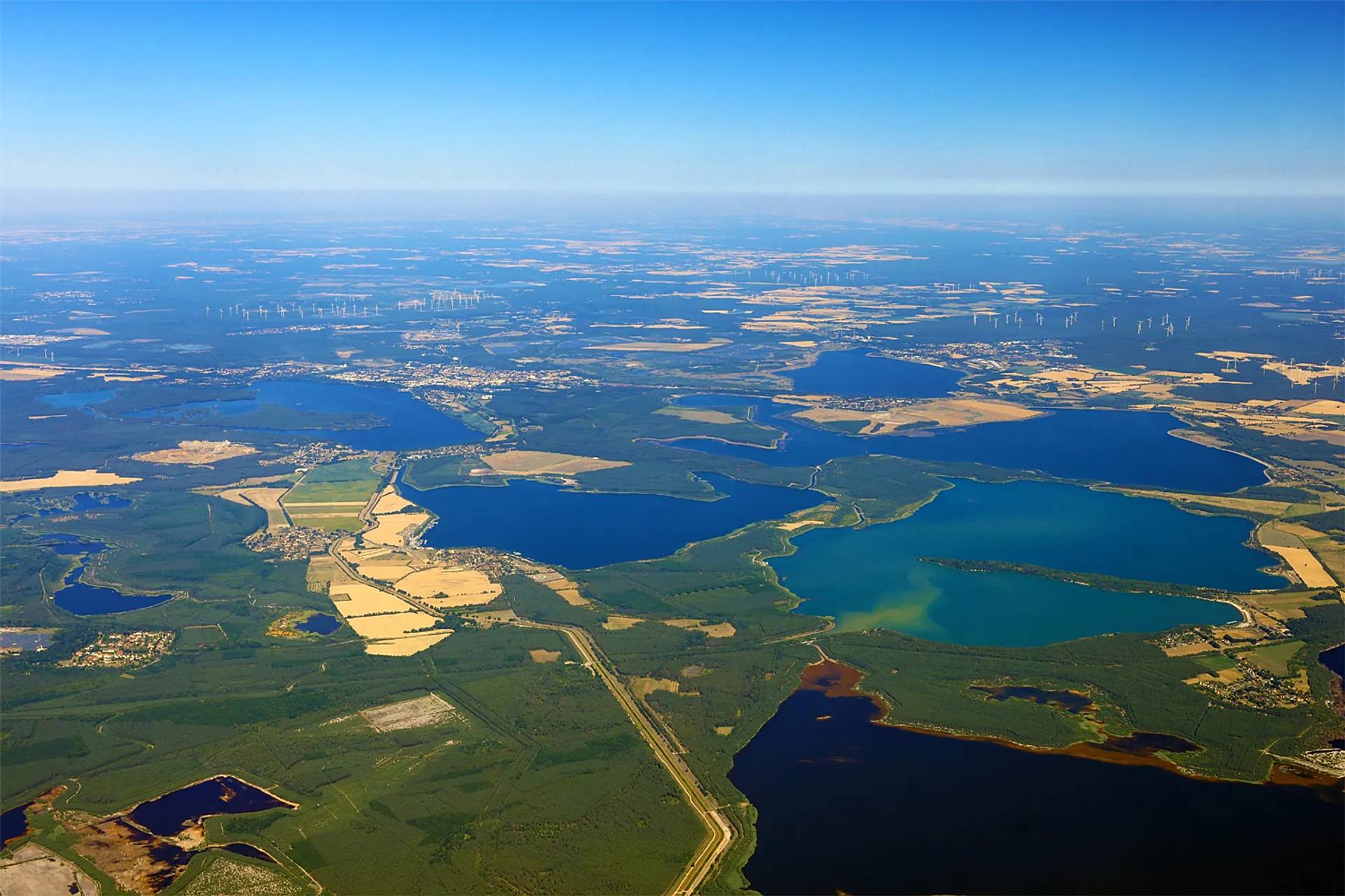 Aerial view of the lake landscape, with bodies of water surrounded by green and brown land