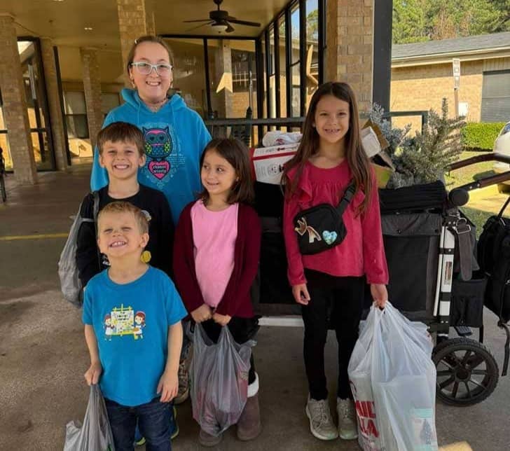 Five young children in front of a wagon filled with decor and holiday supplies