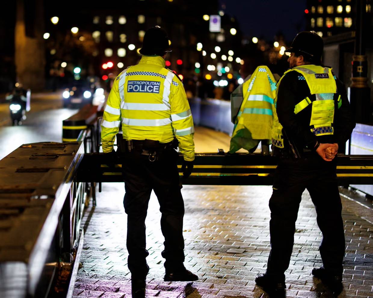 Two police officers in bright yellow shirts at night