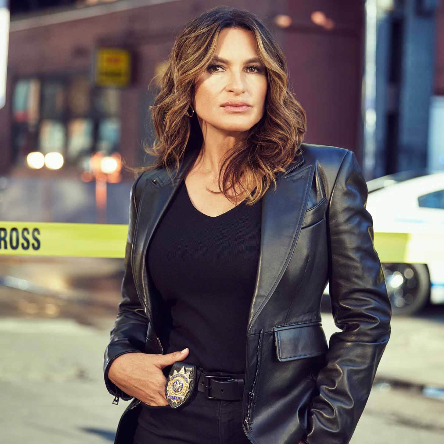 Mariska Hargitay posing in-character as Olivia Benson in front of yellow police tape