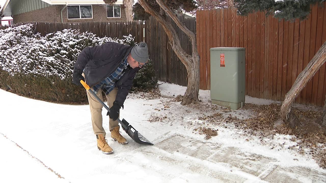 A person shoveling snow on a sidewalk