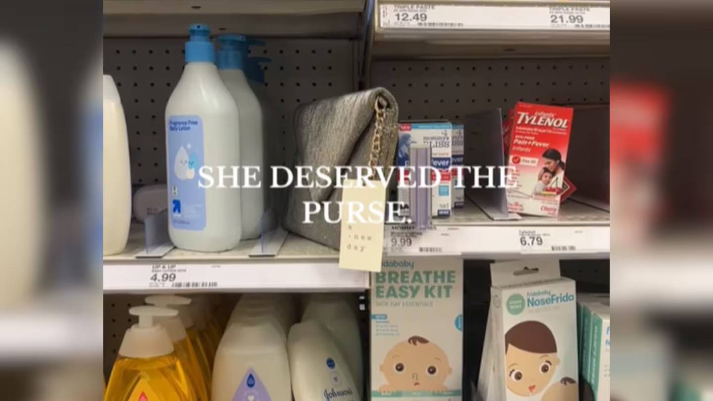 Shelves with baby body lotion, baby medicine, soap, with a silver-colored purse misplaced on the shelf and "SHE DESERVED THE PURSE" overlaid in white text