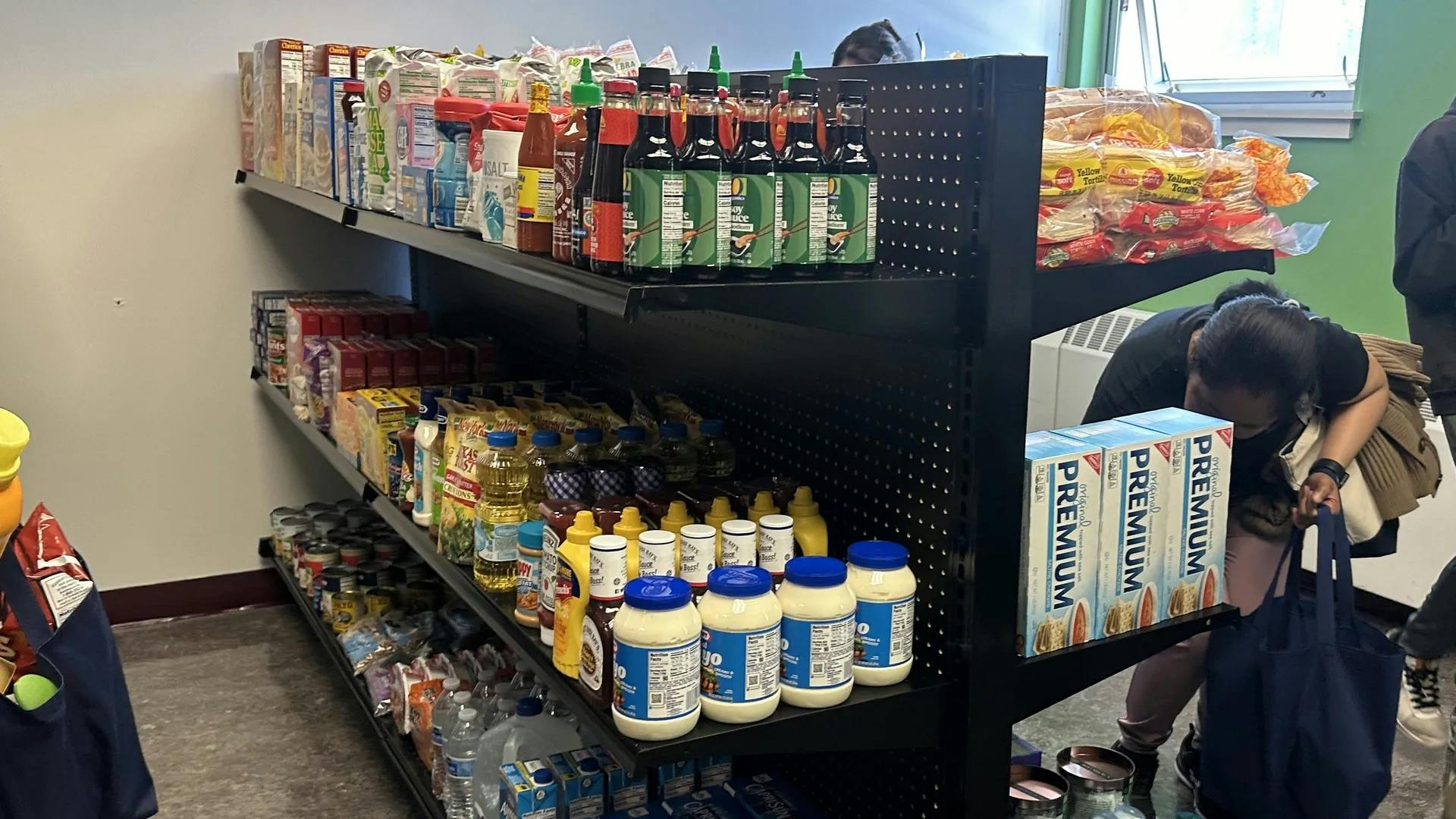 A black shelving unit stocked with boxes, bottles, jars, and containers of food, condiments, ingredients, and more