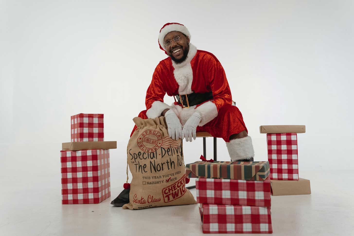 Black Santa on a stool with presents around him