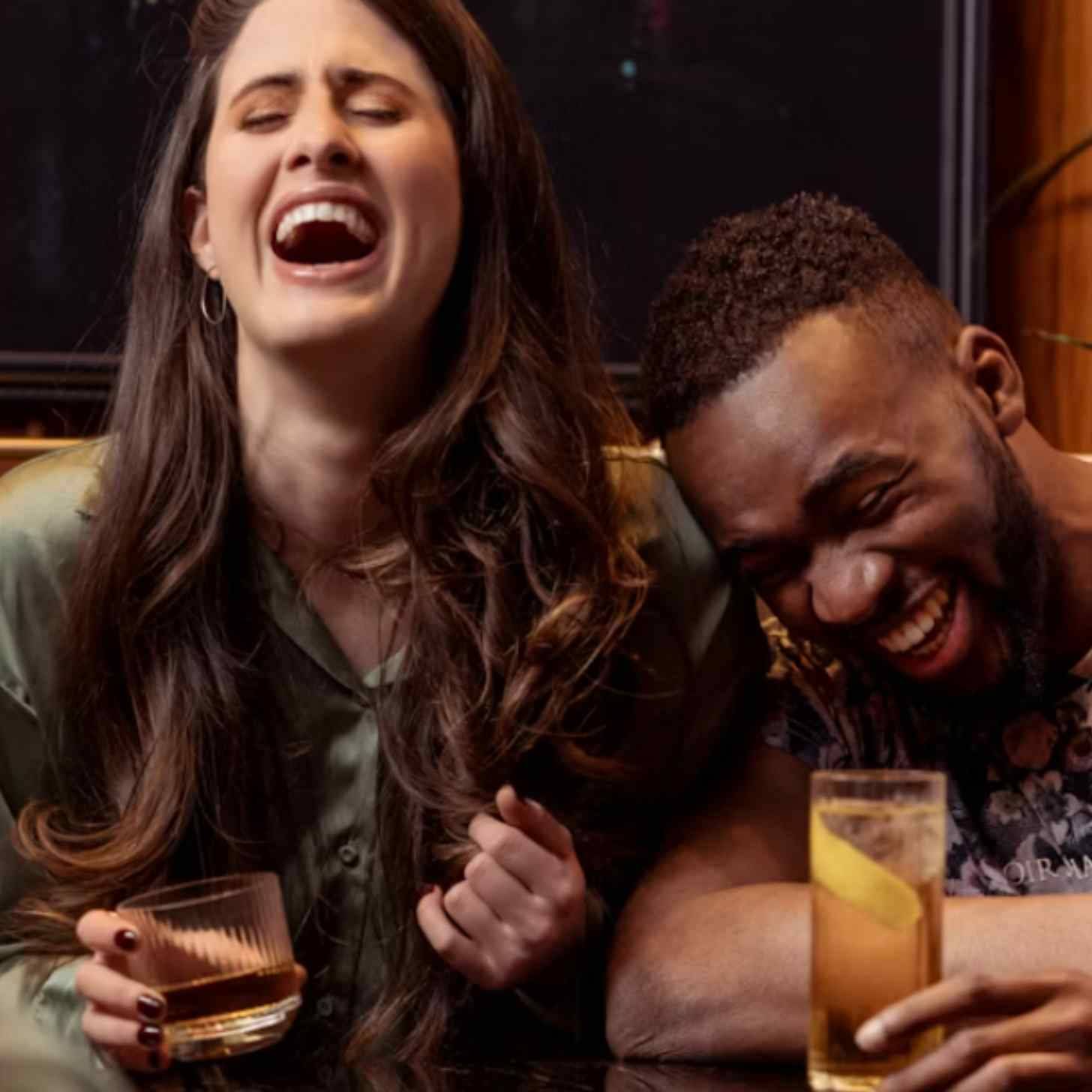two people laughing holding beverages