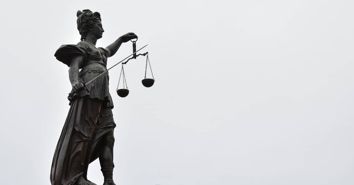 Statue of a person holding scales of justice and a sword