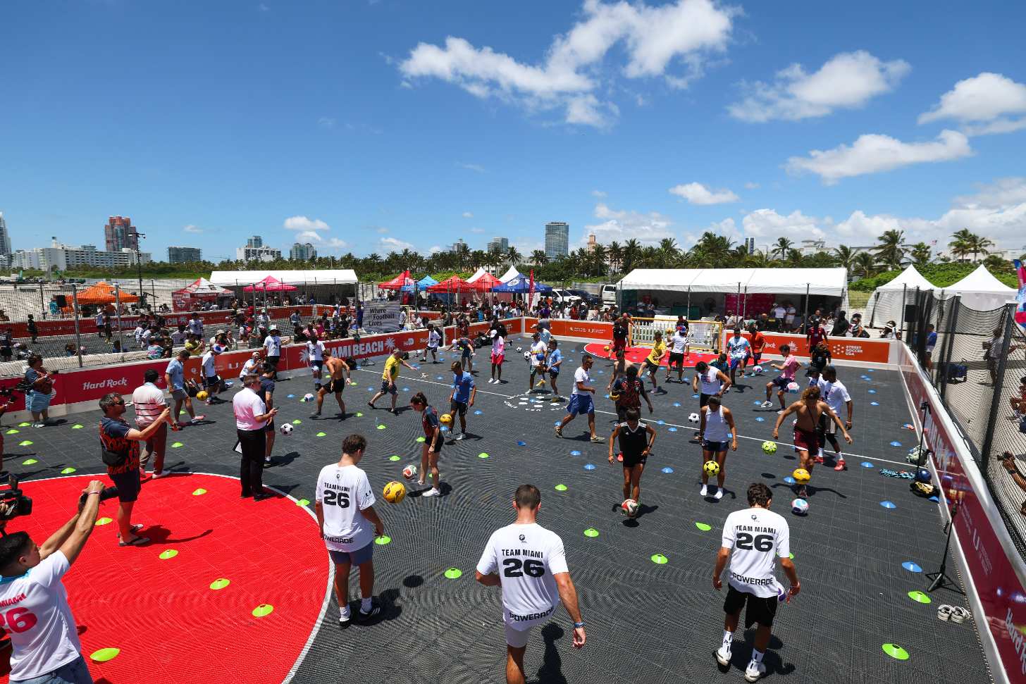 A street soccer "field" filled with people dribbling a soccer ball