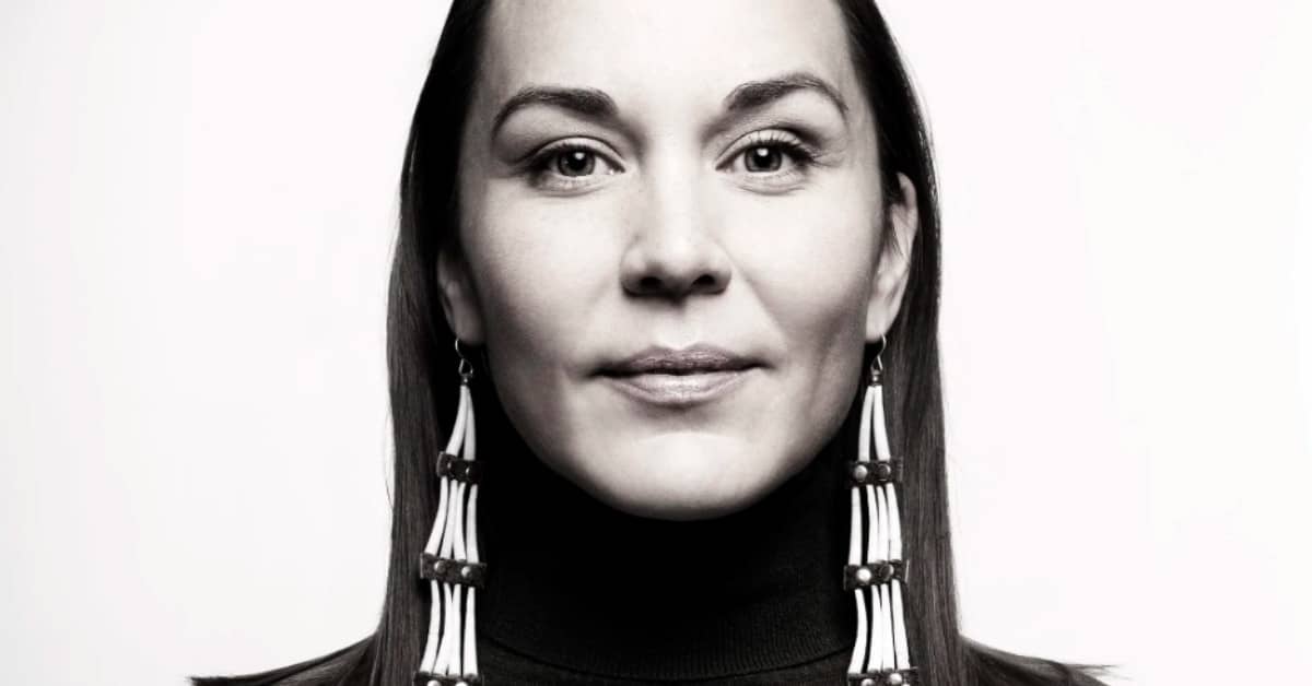 Black and white photo of a woman pictures from the shoulders up to her forehead