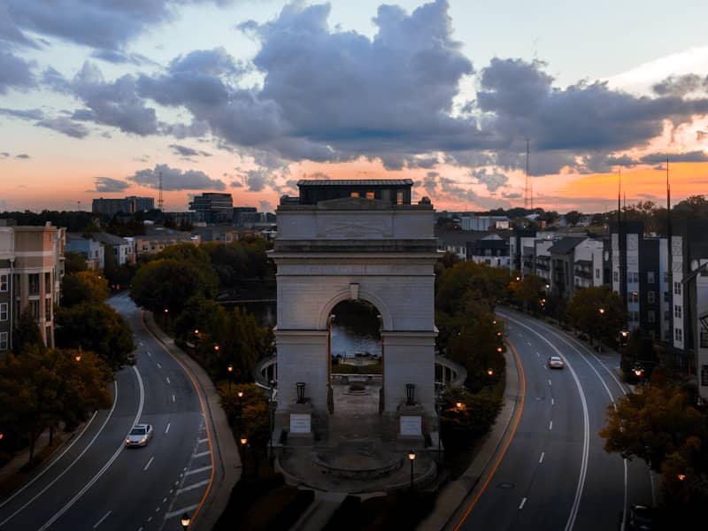 Grand arch monument with roads at sunset