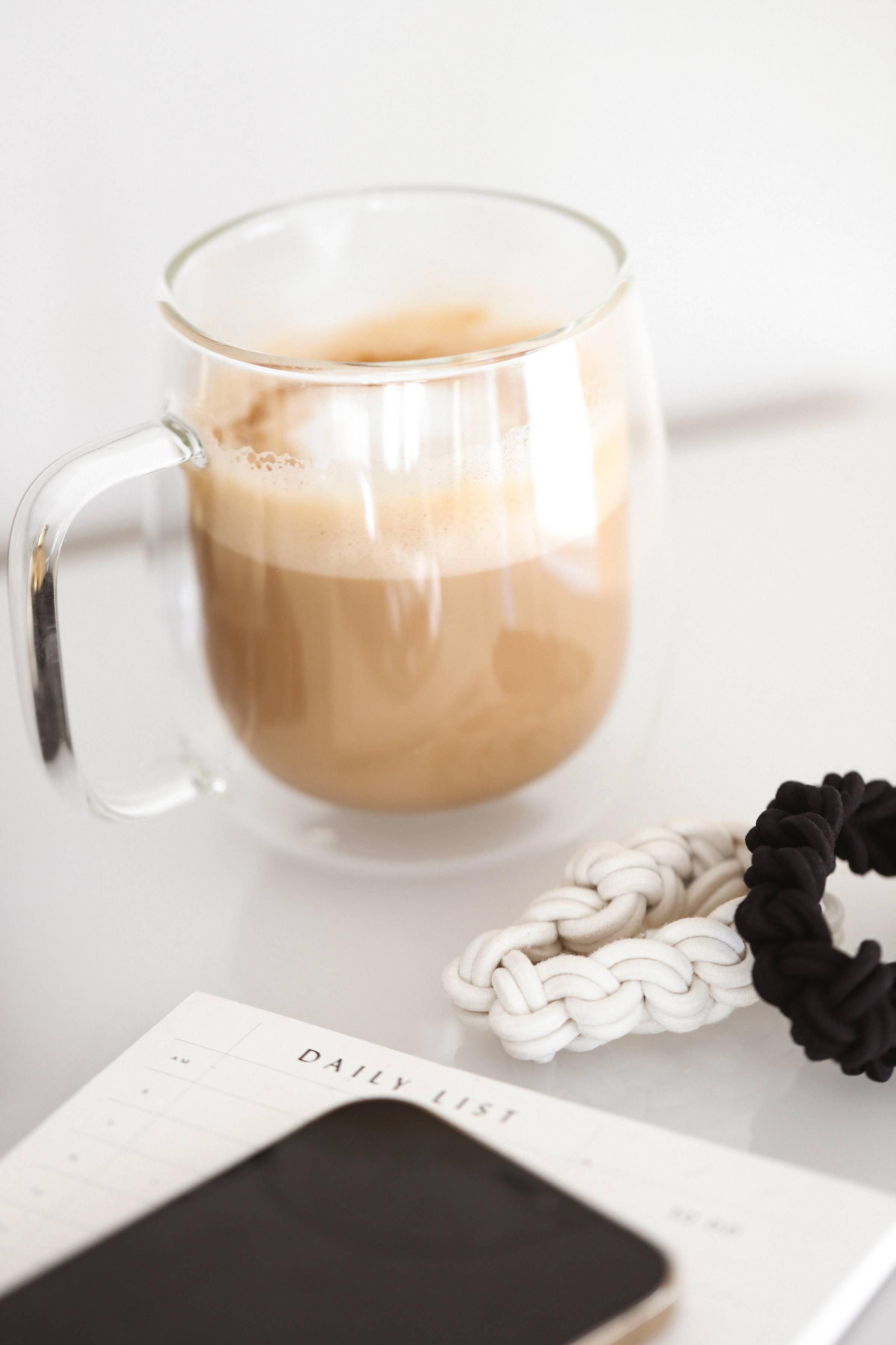 A cup of coffee with some hair scrunchies next to it