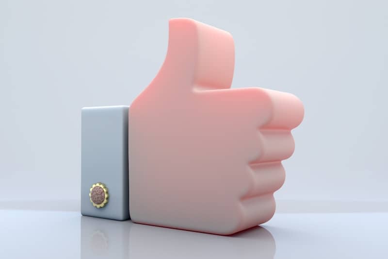 A pink thumb up symbol on a white background.