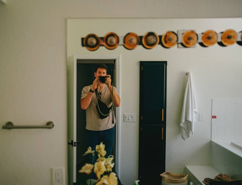 A man taking a photo in a bathroom mirror.