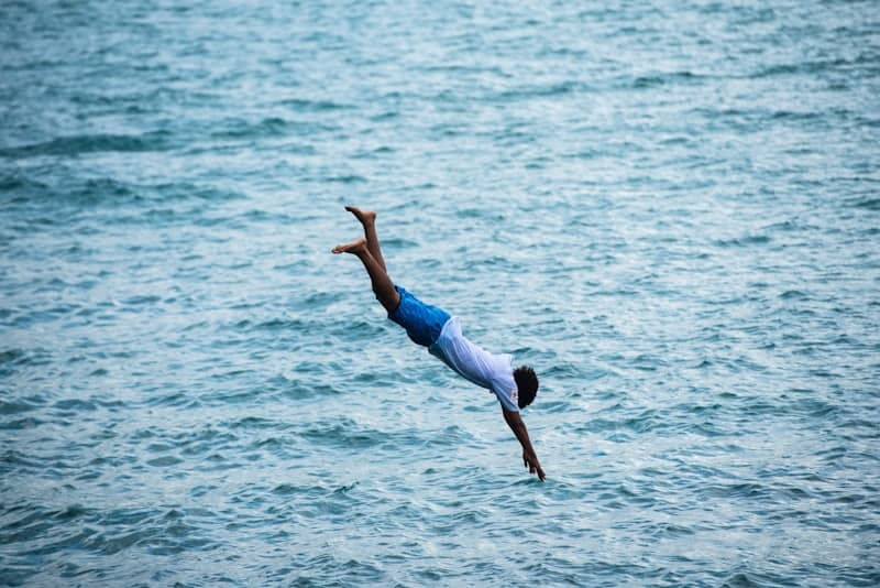 Man dives into the ocean.